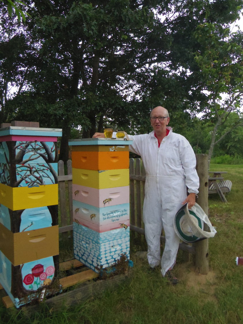 Master beekeeper Dane Pursley stands with the hive boxes at the Barrington Farm School.
